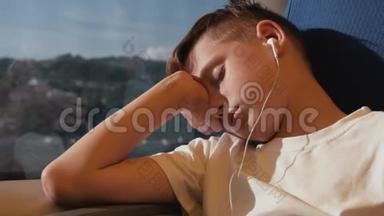 那个男孩在火车车厢的窗边睡觉。 这个男孩正在周游世界。 火车上的旅游男孩